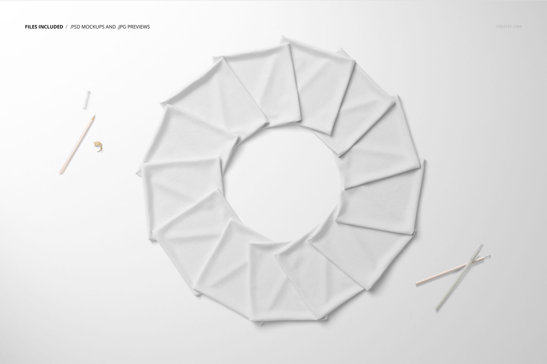 Folded white fabric pieces arranged in a circular pattern on a flat surface, viewed from above.
