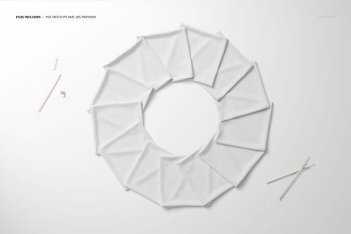 Folded white fabric pieces arranged in a circular pattern on a flat surface, viewed from above.