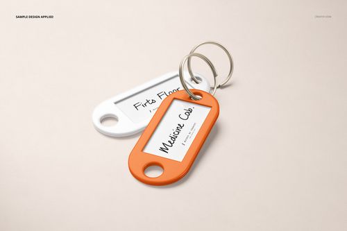 Mockup of two key tags with metal rings, featuring white and orange frames and paper inserts, arranged side by side.