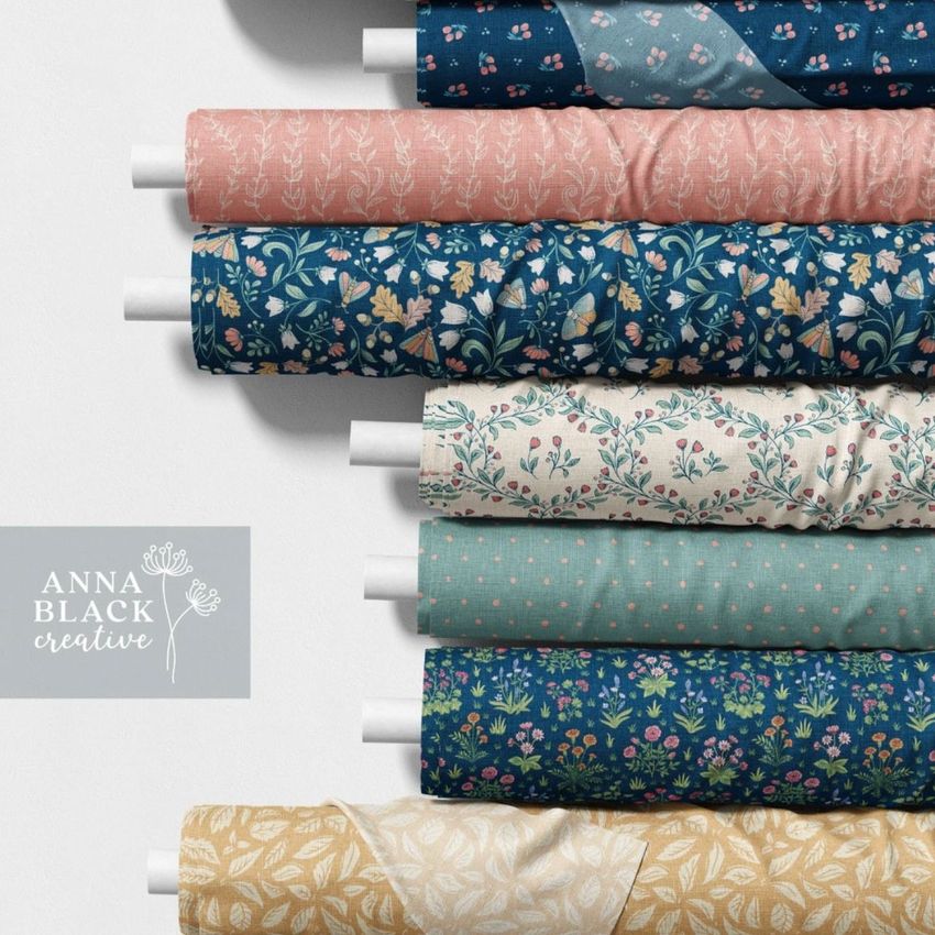 Fabric rolls mockup featuring seven rolls with various floral and geometric patterns in blue, pink, teal, and cream tones.