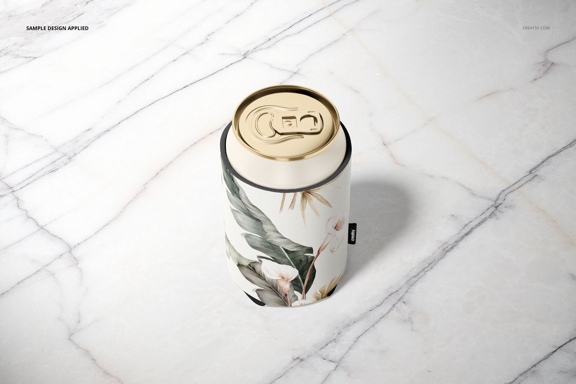 Mockup of a neoprene can cooler featuring botanical leaves and flowers, viewed from above on a marble background.