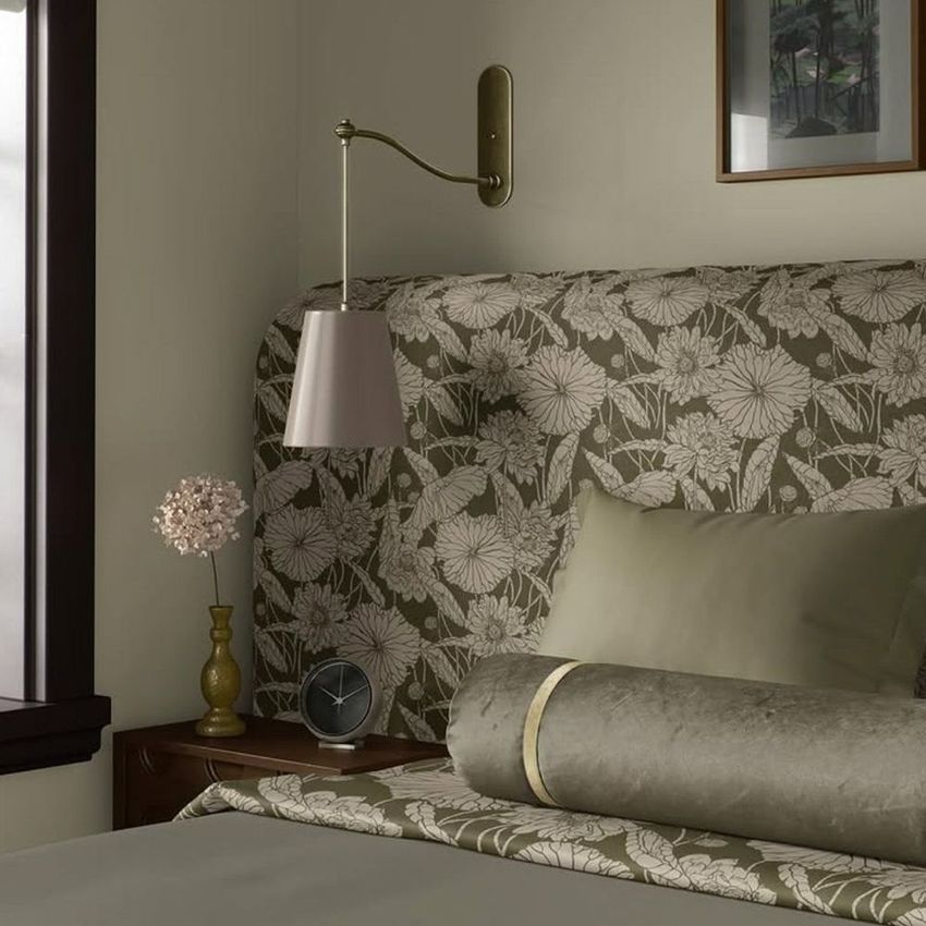 Bedroom mockup scene featuring a bed with a patterned headboard, neutral bedding, a bedside table, and soft lighting.
