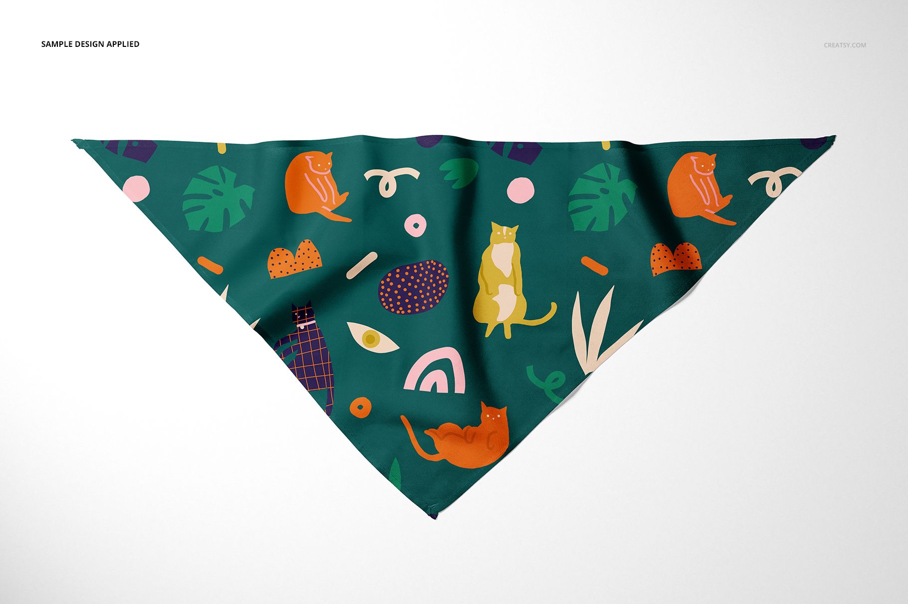 Triangular pet bandana mockup with colorful cat and abstract patterns on a dark green background, front view.
