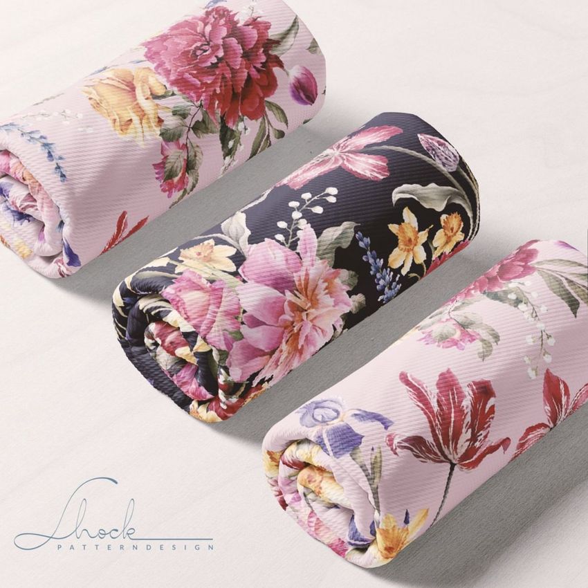 Rolled fabric mockups display colorful floral designs on different colored fabric, set on a plain white background.
