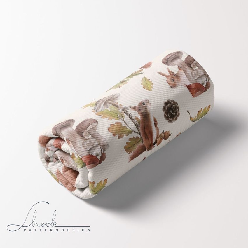 Rolled bullet fabric mockup featuring a repeating autumn woodland pattern with squirrels, rabbits, leaves, and pinecones on white.