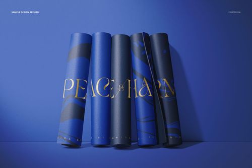 Five rolled yoga mats in blue shades with abstract patterns and gold lettering, arranged upright on a blue surface.