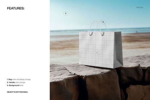 Horizontal shopping bag mockup with grid pattern placed on a stone wall at the beach, front view, clear sky.