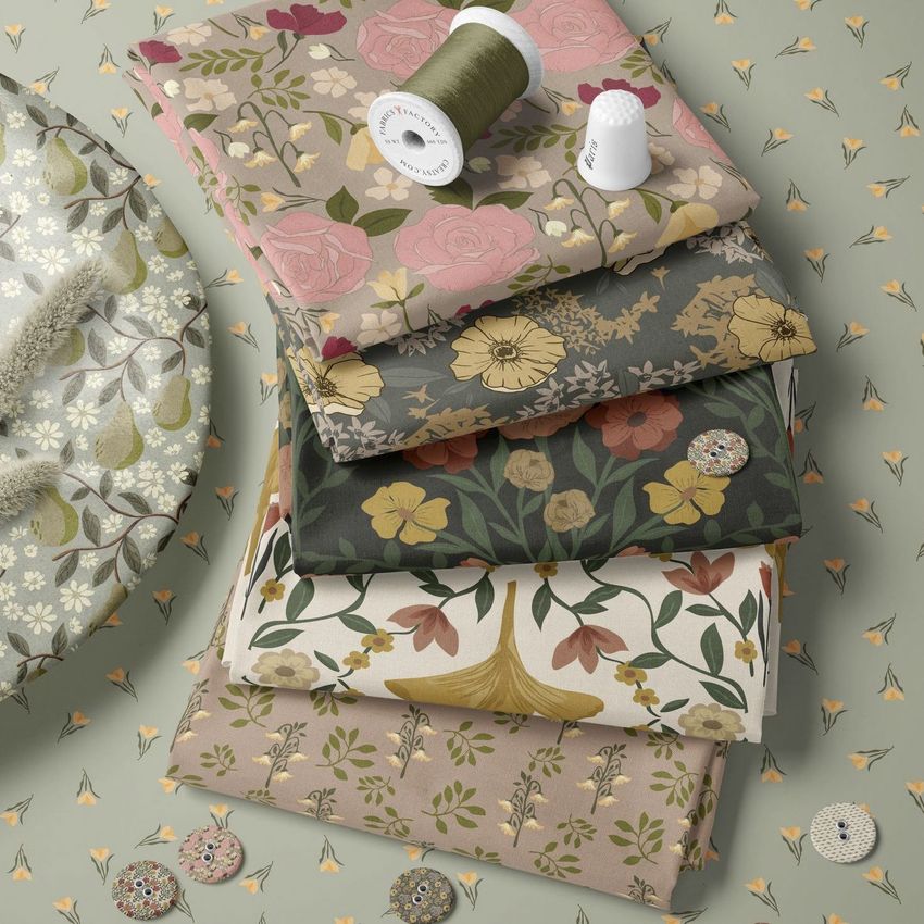 Fabric stack mockup showing five folded fabrics with floral and botanical patterns in muted autumn tones, viewed from above.