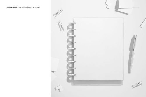 PSD mockup featuring a spiral planner in the center with paper clips, sheets, and stationery scattered around.