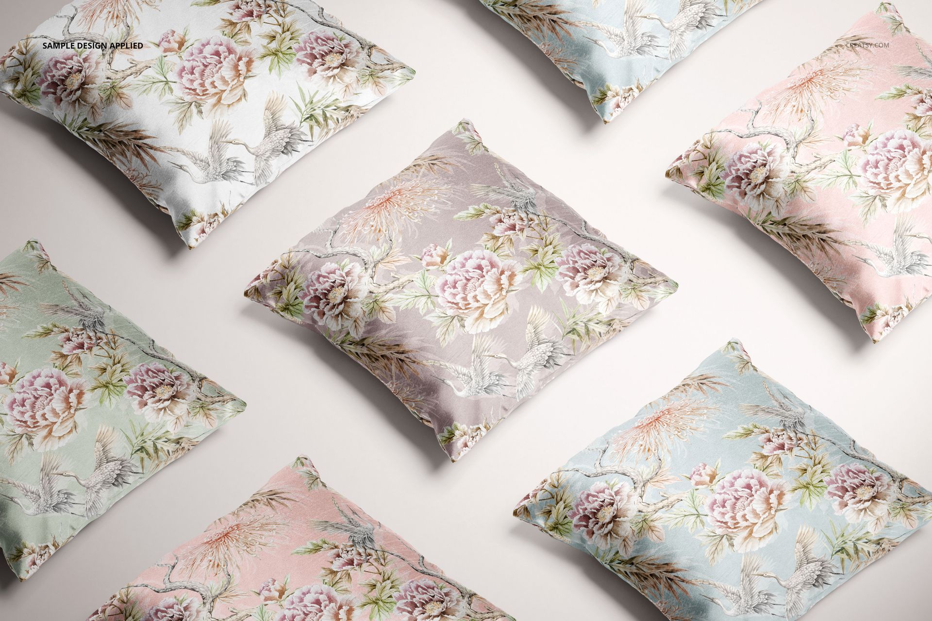 PSD mockup featuring several polyester cushion covers with delicate flower motifs, shown from above on a neutral surface.