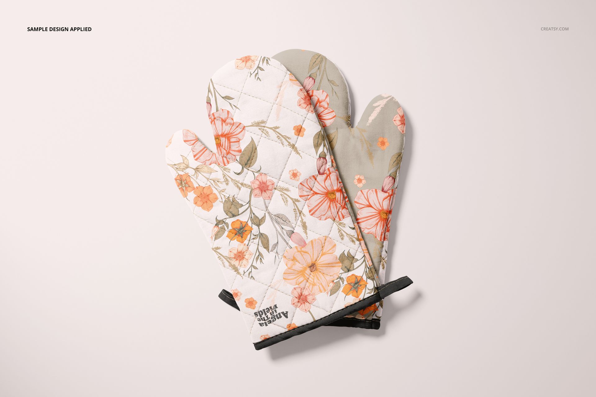 Floral patterned oven mitts in orange and beige hues, presented as a PSD mockup set on a neutral flat surface.