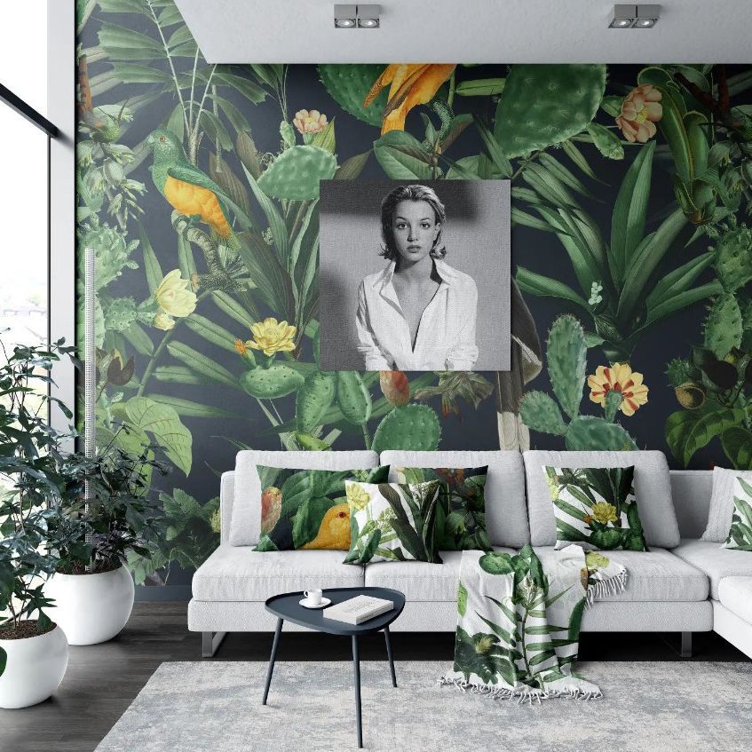 Modern living room sofa mockup with a botanical wallpaper, light gray sofa, tropical-themed pillows, and a round black coffee table.