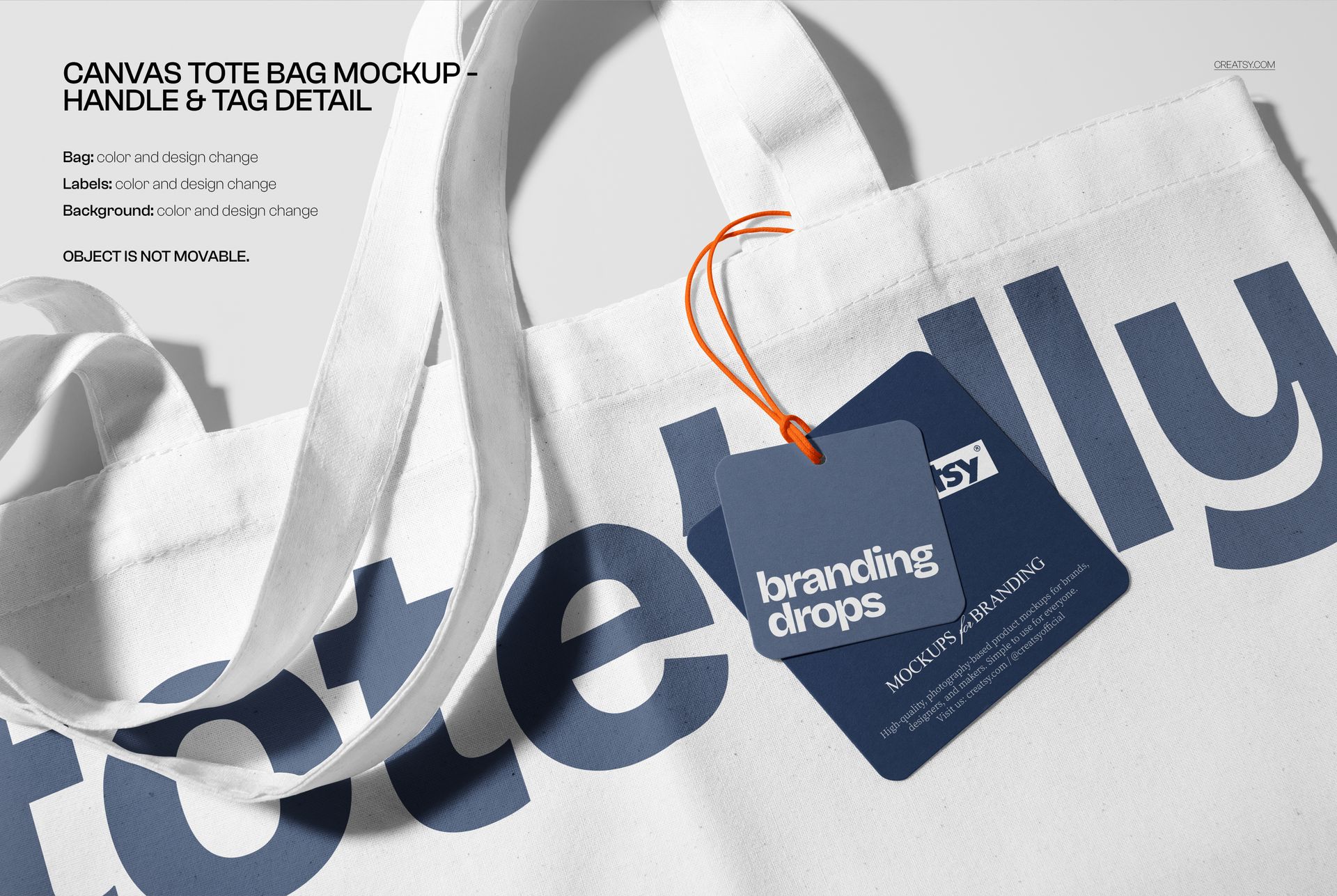 White tote bag mockup with blue graphic text, orange string, and a blue tag displayed on a light background.