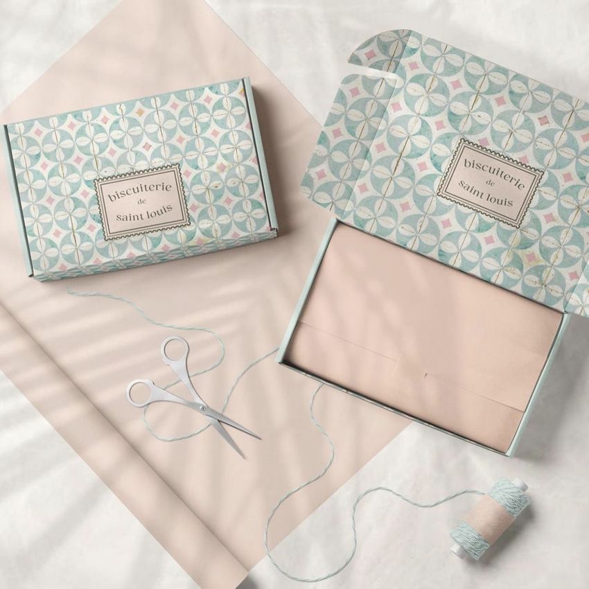 Mailing box mockup featuring two pastel patterned boxes, one closed and one open, displayed on a light background with scissors and twine.