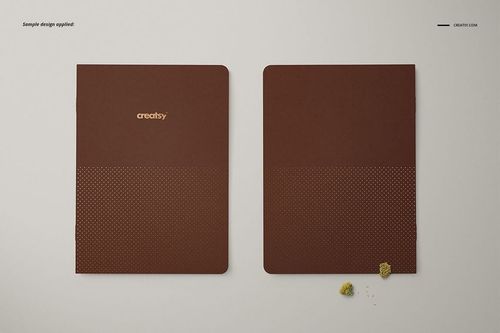 A5 notebook mockup set showing two brown covers, one open and one closed, with minimal props on a pale surface.