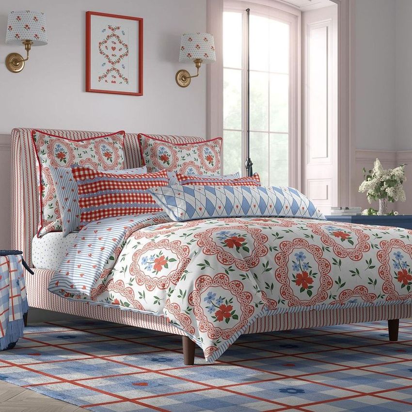 Cottage style bedroom bedding mockup featuring a bed with patterned duvet, pillows, and a blue and red geometric rug.
