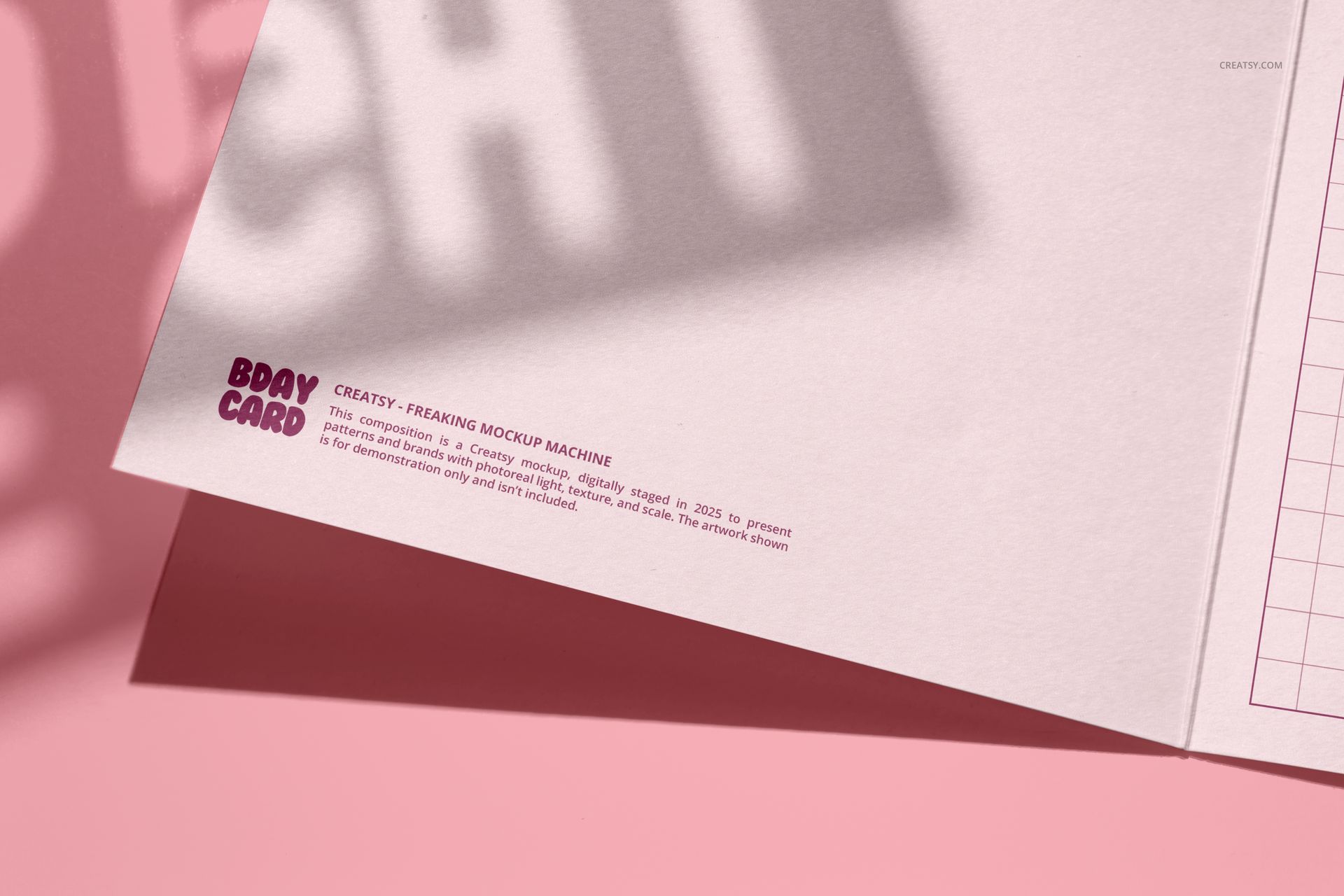 Open small square greeting card mockup on a pink surface, showing inside details and shadow overlay.