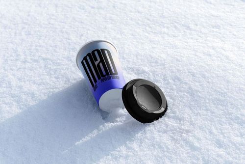 Winter-themed paper cup mockup with bold black text, cup and lid resting on snowy surface, angled perspective.