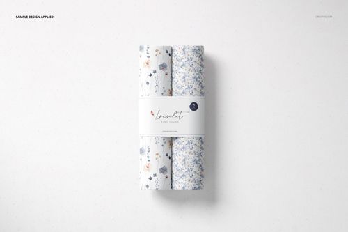 Top view of a changing pad mockup featuring three rolled pads with floral patterns, set on a light background.