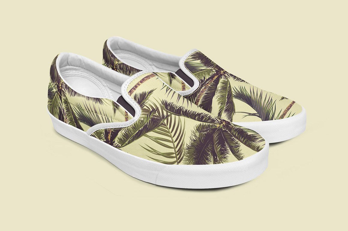 PSD mockup of slip-on shoes with a green and brown palm leaf print, presented at an angled front perspective.
