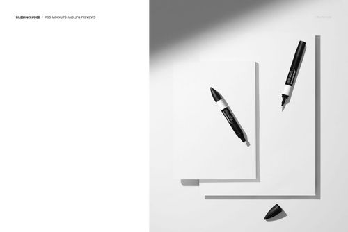 Top view of two colored pencils and two white paper pads arranged on a light surface with strong shadows.