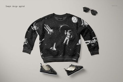 Front view of a baby sweatshirt mockup with a black background and white space-themed illustrations, placed on a light surface.