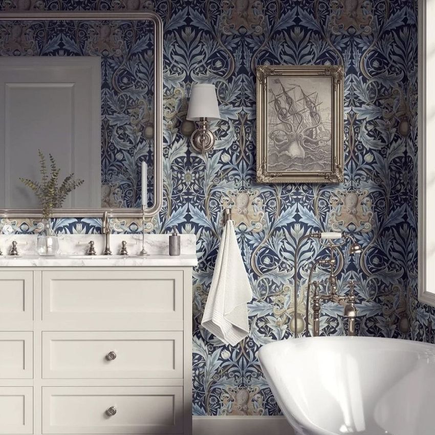 Victorian bathroom wallpaper mockup featuring blue botanical damask patterns, a white vanity, and a framed artwork above a bathtub.