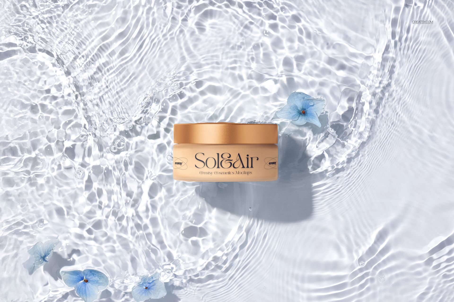 Cosmetics packaging mockup featuring a golden jar on textured water surface with delicate blue flowers, overhead angle.