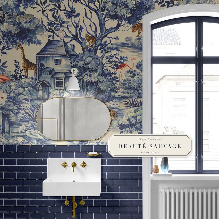Vintage bathroom mockup featuring a white sink with gold fixtures, navy subway tile, and blue toile wallpaper with nature scenes.