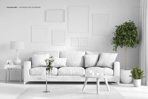 PSD mockup showing a stylish living room with a white couch, decorative pillows, wall frames, and a large indoor plant.