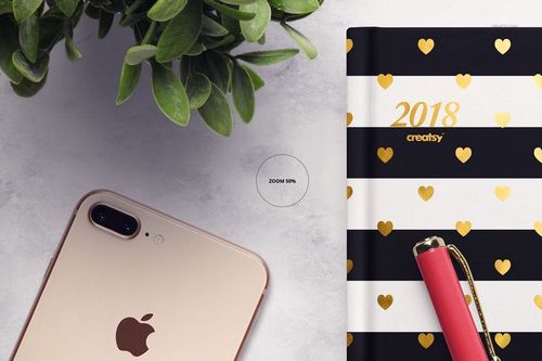 Striped planner mockup with gold hearts, accompanied by a rose gold smartphone and red pen on a marble background.