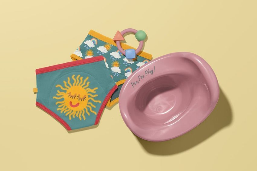 Toddler training pants mockup set with playful sun and cloud patterns, pink potty, and pastel toy on a yellow background.