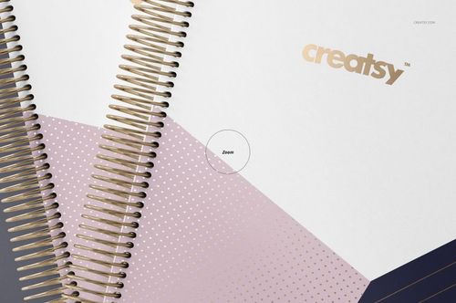 PSD mockup of coil-bound planners showing geometric cover designs in soft pink, white, and gold tones from above.