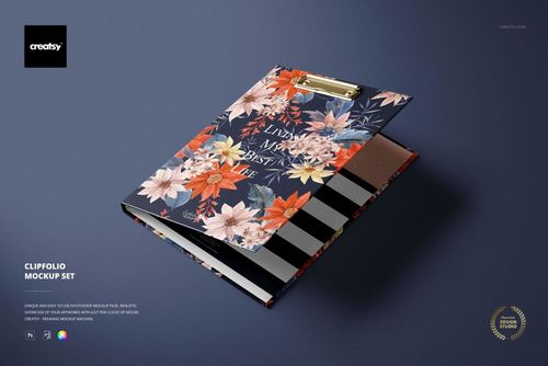 Stationery mockup featuring a floral-patterned clipboard with gold clip, shown from an angled top view on a dark surface.