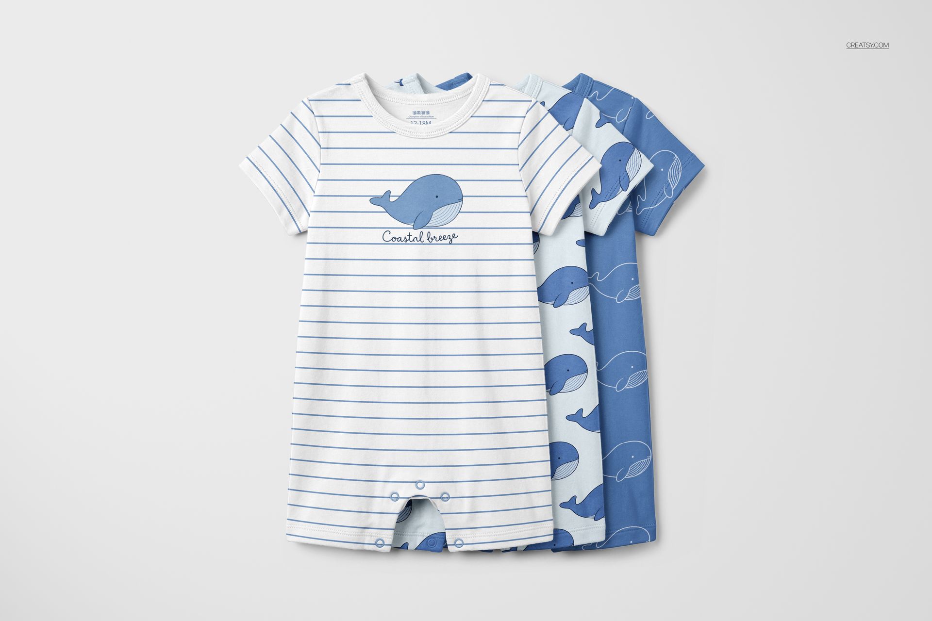 PSD mockup set showing three short-sleeve baby rompers, each featuring playful whale designs in blue tones.