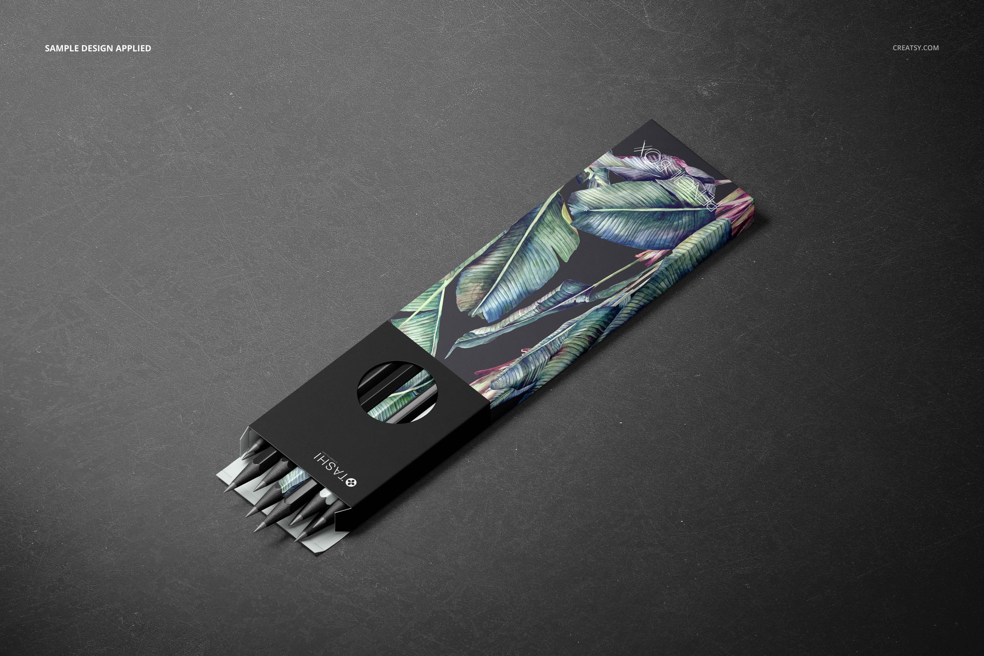Pencil box mockup featuring a black case with green leaf design, displayed at an angle on a dark background.