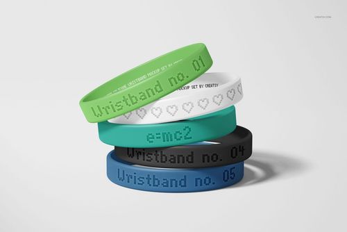 PSD mockup showing five silicone wristbands with various colors and debossed designs, displayed in a pile.