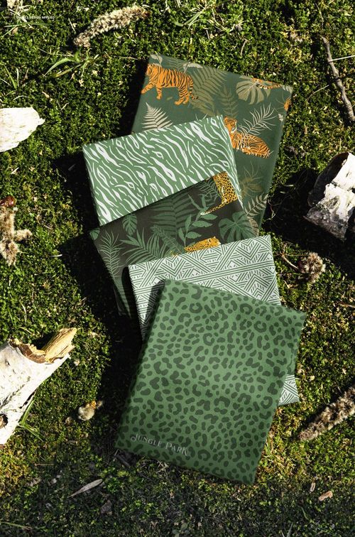 PSD mockup showing a vertical stack of green fabrics with various nature-inspired designs on moss and tree bark.