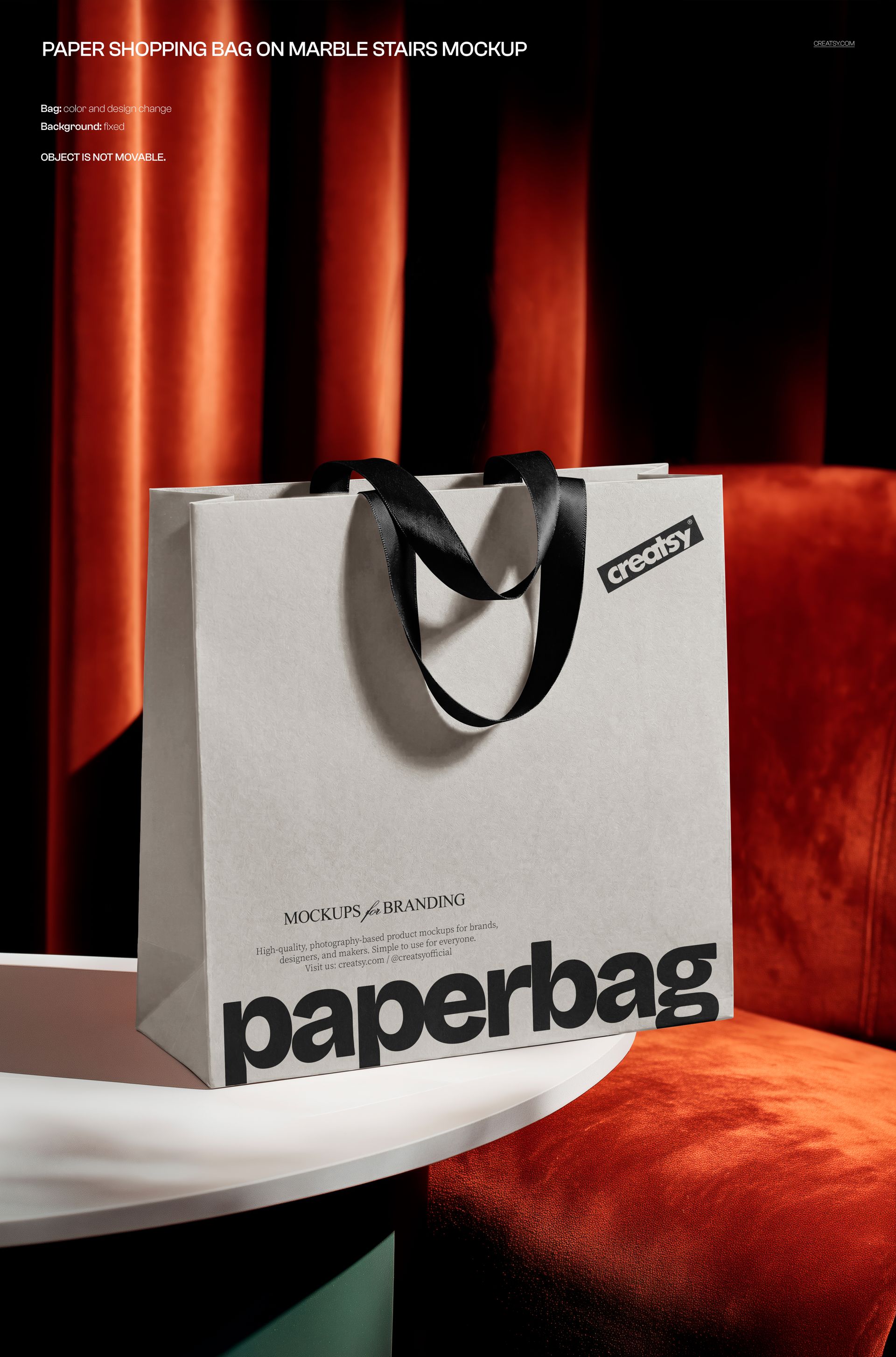 White paper bag mockup with black handles displayed on a round marble surface, red curtains in the background.
