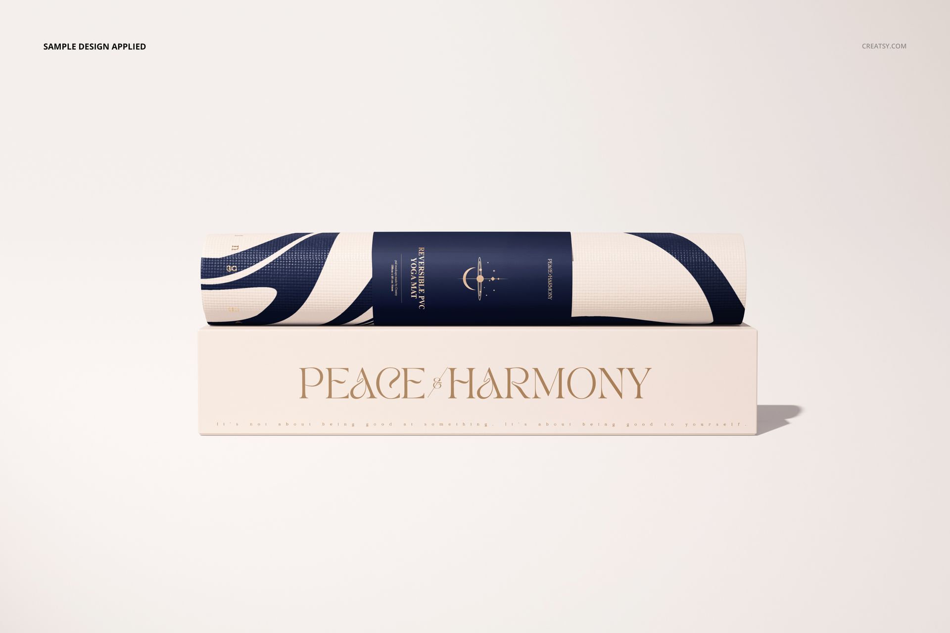 Yoga mat mockup showing a rolled mat with modern navy and white pattern on a box with gold lettering, neutral background.