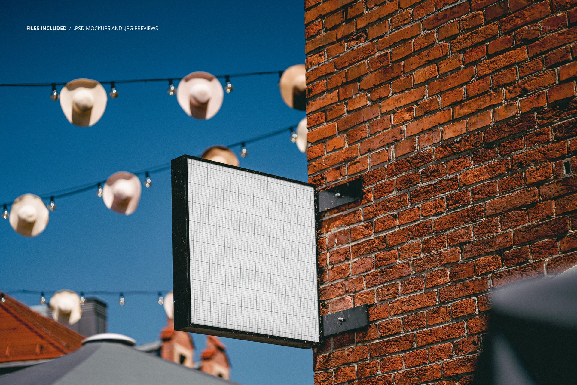 Square street sign mockup with a grid pattern mounted on a red brick wall, viewed from a slight angle outdoors.