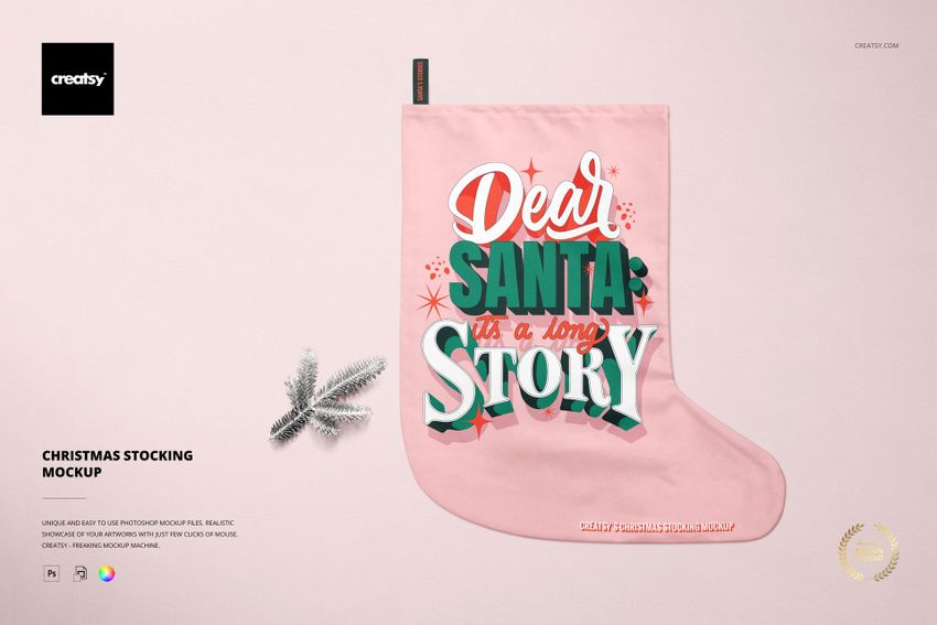 Christmas stocking mockup with a pink fabric, bold festive lettering, and a small silver pine branch on a light background.