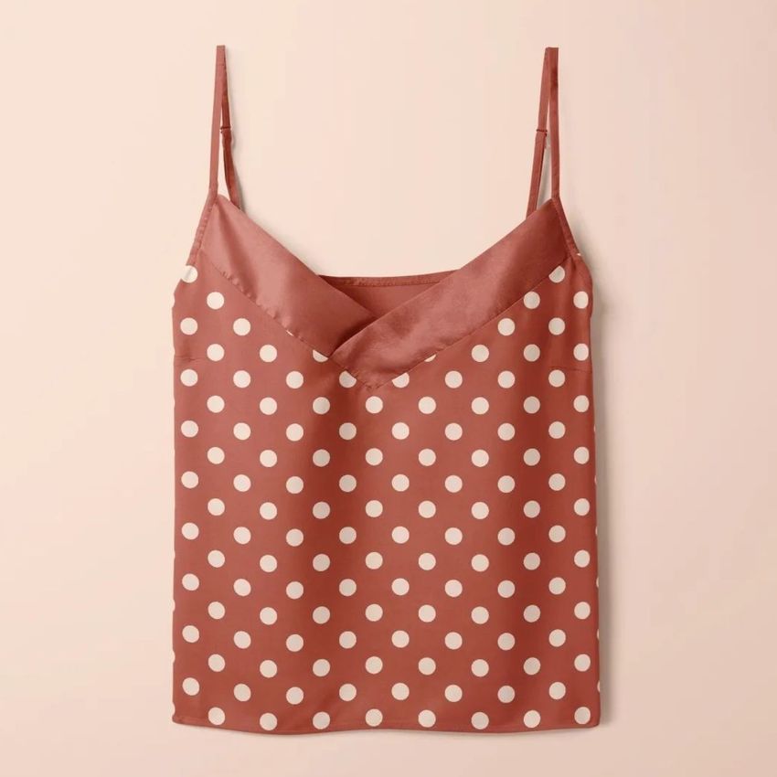Short silk pajama mockup featuring a sleeveless top with white polka dots on a muted rose background, shown flat against a light surface.