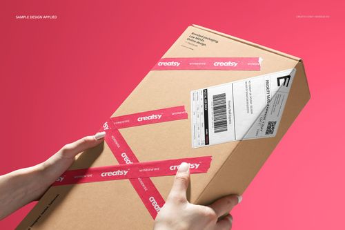 PSD mockup showing a person holding a kraft packaging box with shipping label and pink tape, with a vibrant pink background.