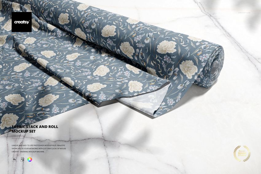 Fabric Stack and Roll PSD mockup featuring blue rolls with white flowers, placed on a marble-textured surface.