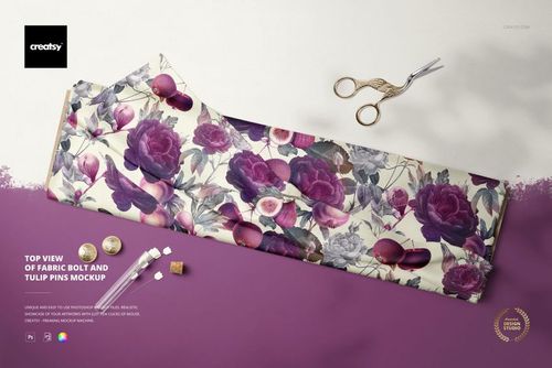 Fabric bolt mockup displayed from above, featuring purple flowers and leaves, with tulip pins and sewing tools nearby.