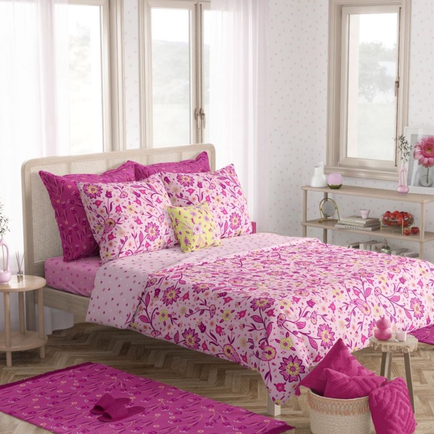 Boho bedroom bedding mockup featuring a bed with pink and purple floral-patterned sheets and pillows in a bright room.