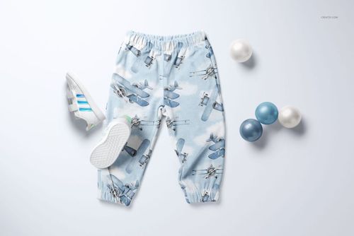 PSD mockup of baby sweatpants in a sky-themed design, shown with blue and white balls and a pair of small sneakers.