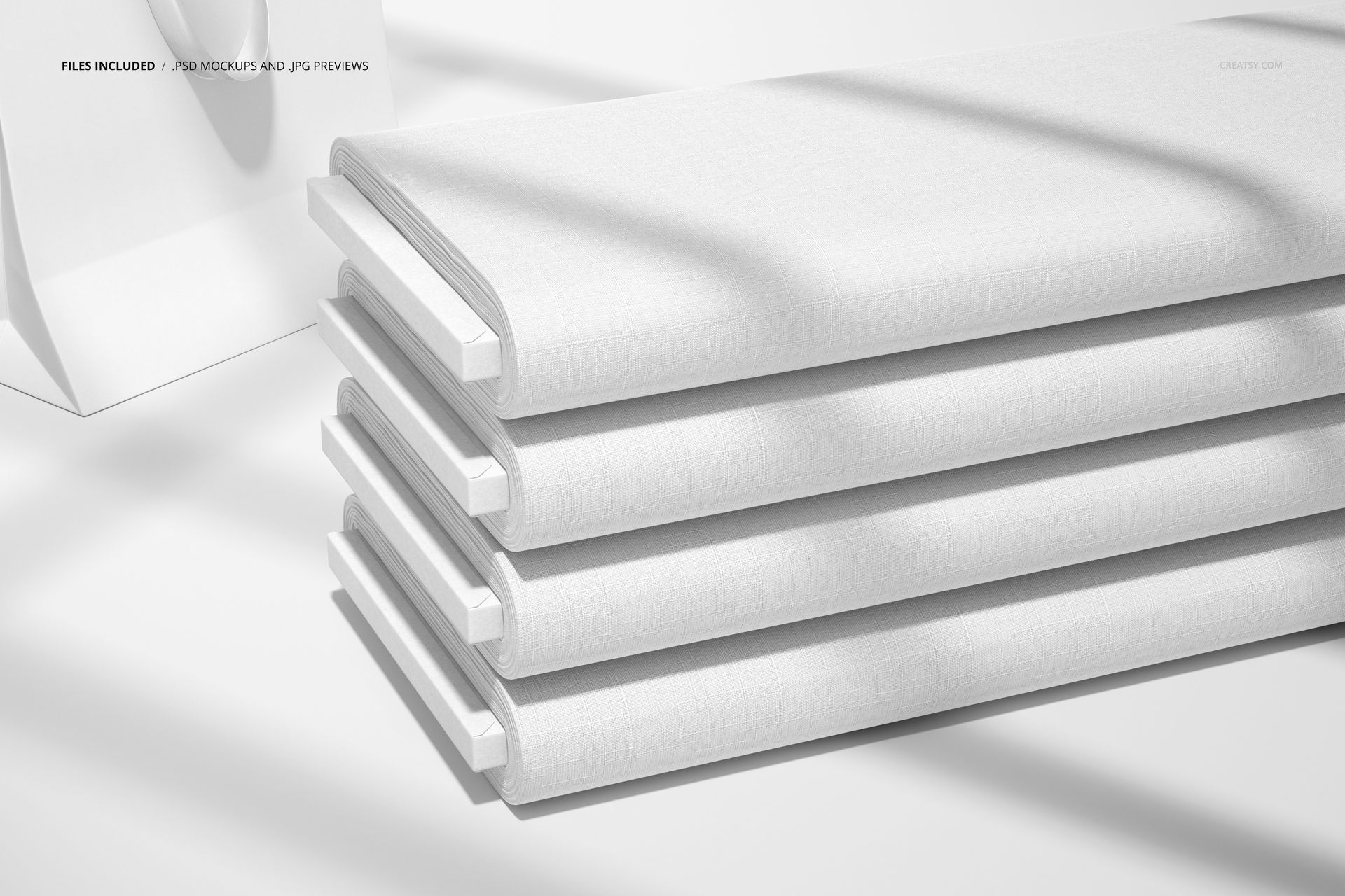 Fabric bolts mockup featuring four folded white bolts, illuminated by natural light with gentle shadows across the surface.