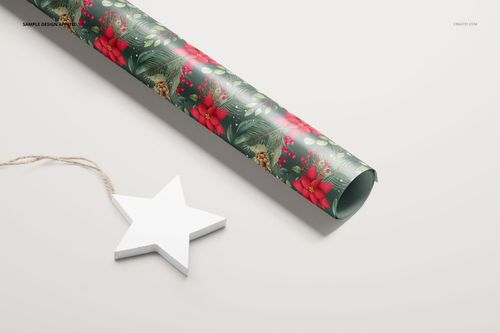 PSD mockup of a rolled wrapping paper with Christmas botanical design, displayed on a neutral background with a star prop.